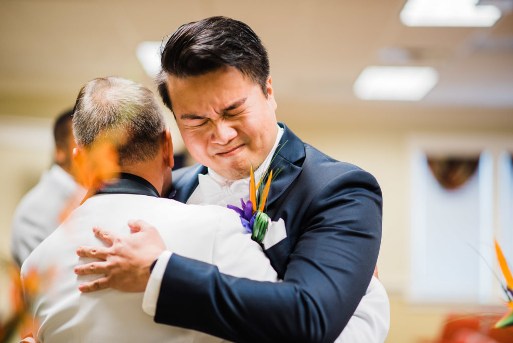Groom hugging father during the ceremony.
Photo by Black Tie & Co. www.btcweddings.com