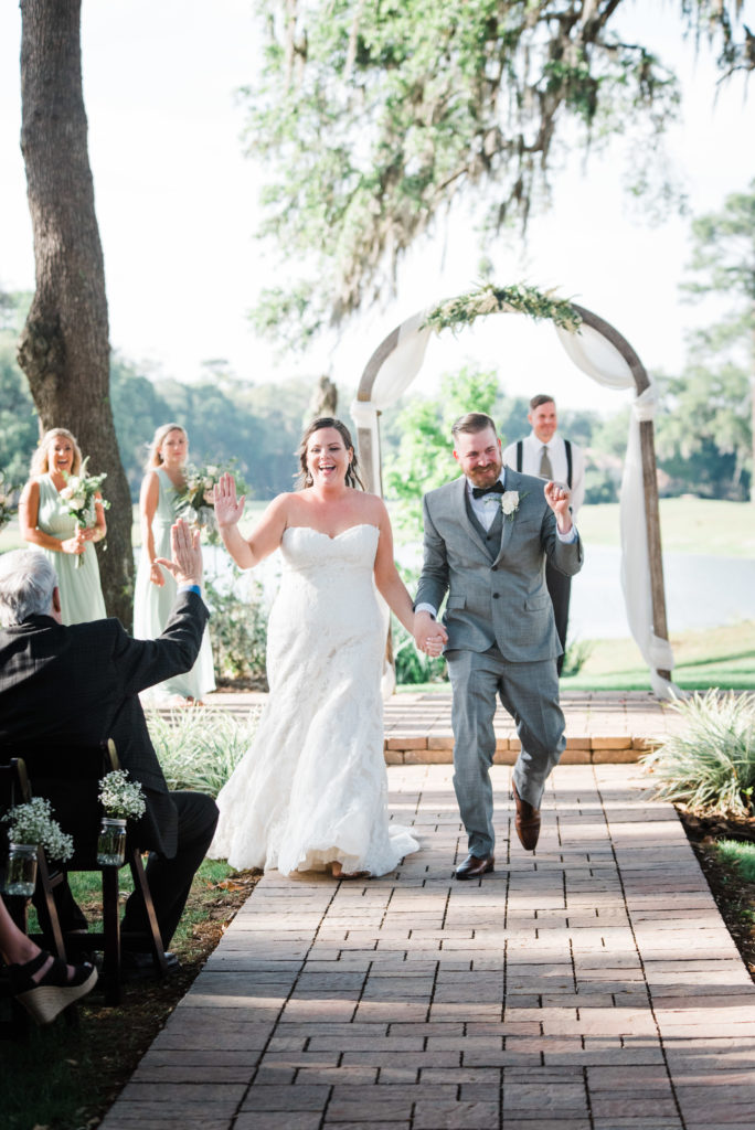 newlyweds waking down the aisle after saying I do and high fives her father
Queen's Harbour country club in Jacksonville Florida Photography by Chabeli Woolsey Black Tie & Co www.btcweddings.com