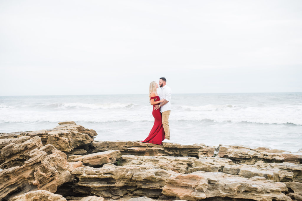 couple stands on rocks on beach and stare into each others eyes. Palm coast beach engagement session.
photo by Chabeli Woolsey of Black Tie & Co www.btcweddings.com