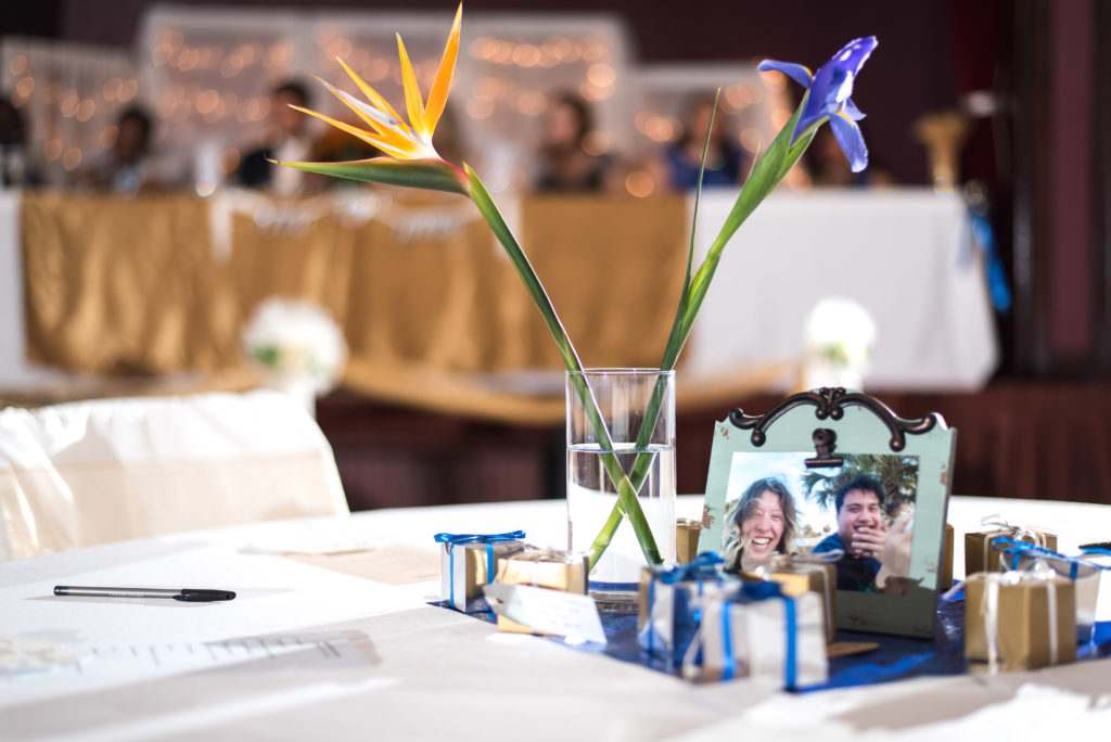 Birds of paradise centerpiece with photo of bride and groom during their courtship in a frame on the table
Alachua Woman's Club in Florida 
Photo by: Black Tie & Co. (www.btcweddings.com)