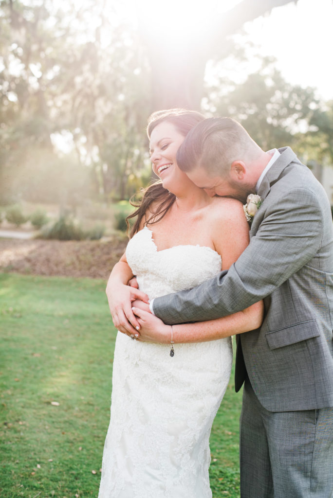 Bride and Groom hugging on the golf course at the Queen's Harbour country club in Jacksonville Florida Photography by Chabeli Woolsey Black Tie & Co www.btcweddings.com